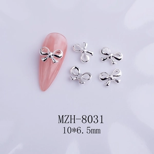 Macro shot of silver alloy bow nail charms on pink manicure showing 10x6.5mm size details