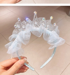 Detail of light blue mesh tiara headband with shimmering rhinestones and white pearls