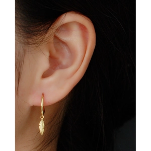 Chic 925 sterling silver hoop earrings with gold feather charms on female model ear