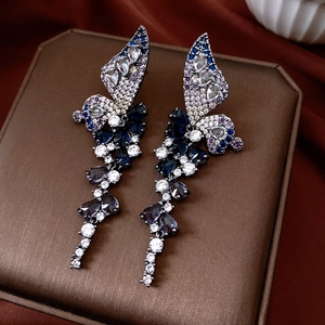 Detail shot of vintage wing drop earrings with blue and purple cubic zirconia stones