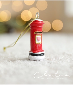 Detail of red Christmas mailbox ornament with snow details and gold hanging string