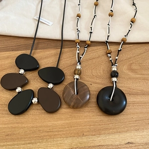 Detail of vintage resin and wood bead pendants on woven bohemian style necklaces