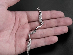 Close-up of irregular textured silver bracelet on hand with minimalist abstract design