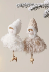 Détails des décorations de poupées anges en peluche sur des branches de pin enneigées