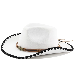 Détail d'un chapeau de cowboy blanc avec bord tressé noir et boucle de crâne en bronze