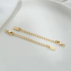 Close-up of 14K gold-filled lobster clasps with Lucky tags and extender chains