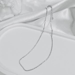 Detailed view of an S925 sterling silver chain resting on a white silk decorative tray