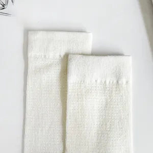 Close-up of white combed cotton socks showing fine knit ribbing and breathable texture