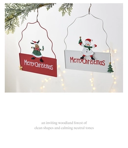 Close-up of Christmas iron welcome sign with snowman and elk on festive pine branches