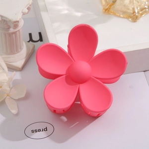 Detail of pink flower hair claw clip with matte texture on a decorative setup