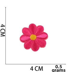 Detail of pink flower embroidery patch with yellow center and precise stitching