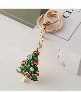 Detailed macro view of a green enamel Christmas tree keychain with red bow and rhinestones