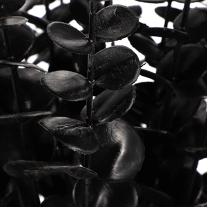 Close-up of black artificial eucalyptus leaves with sharp textures and high contrast