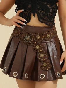 Detail of brown faux leather belt featuring heart-shaped metal studs and sun carvings