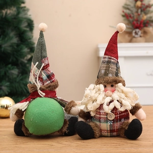 Pair of handmade linen plaid Christmas plush gnomes on a wooden desk with festive background