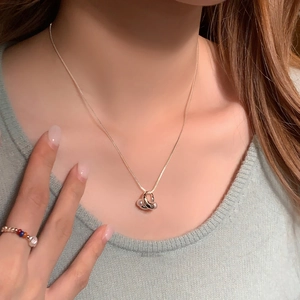 Primo piano della collana placcata oro 18K con anelli cavi e perle su una modella