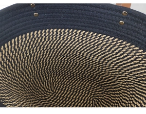Detailed close-up of woven cotton tote bag featuring contrast colors and gold metal rivets