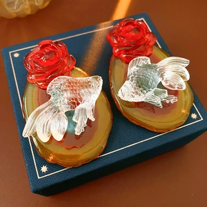 Detailed view of amber floral resin earrings with red roses and clear goldfish design