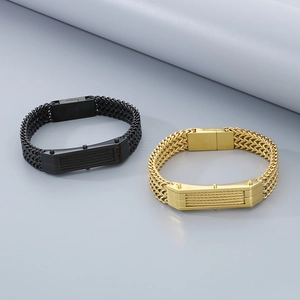 Dettaglio di bracciali a catena intrecciata nera e oro su sfondo grigio professionale