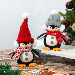 Christmas plush penguin dolls with knit hats and scarves in festive holiday setting
