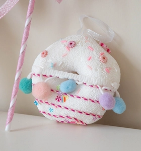 Detailed close-up of a plush donut Christmas tree ornament with colorful macaron accents