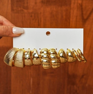 Close-up of gold geometric earrings set with hammered and textured metal finishes