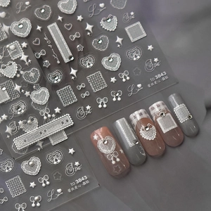 Close-up of 3D lace heart and butterfly nail stickers with rhinestones for DIY nail art