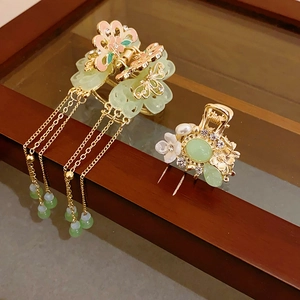Detailed view of Chinese style flower hair claws with pearl tassels on a wooden frame