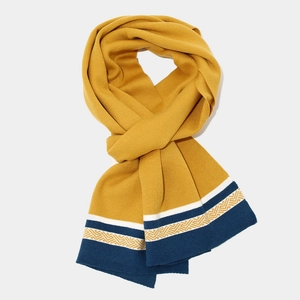 Detail of mustard yellow knit scarf with navy blue geometric patterns and contrast trim