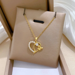 Close-up of titanium steel gold heart necklace with butterfly and zircon inlay