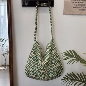 Detailed texture of green floral pattern on large canvas shoulder bag with tulip motifs