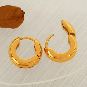 Minimalist chunky golden hoop earrings with polished finish on acrylic display
