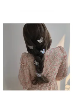 Gros plan de barrettes papillon holographiques stylisées sur une coiffure tressée