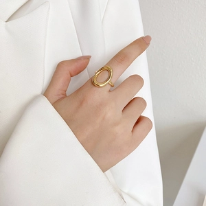 Minimalist 18k gold plated stainless steel open oval ring worn by a model in white