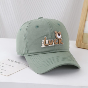 Close-up of sage green cotton baseball cap with cute bear Luck patch detail