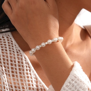 Gros plan détaillé du bracelet en perles avec espaceurs diamantés sur dentelle blanche