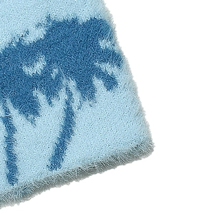 Detailed close-up of soft faux mink fur texture with blue palm tree jacquard pattern