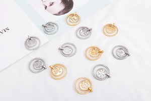 Detailed view of hollow tree of life pendants in gold and silver stainless steel finish