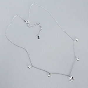 Detailed close-up of s925 silver necklace featuring heart and floral diamond charms