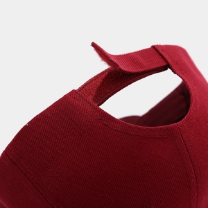 Detail of red cotton baseball cap featuring an adjustable Velcro strap closure