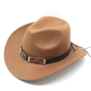 Detail view of brown western cowboy hat with leather band and golden bull head emblem