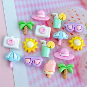 Macro shot of summer-themed resin charms including coconut trees and sunglasses for DIY crafts
