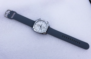 Macro detail of square silver watch with gray silicone strap and Etmido dial