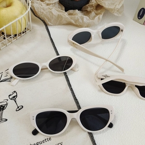 Retro cream cat-eye sunglasses with dark lenses and metallic star accents