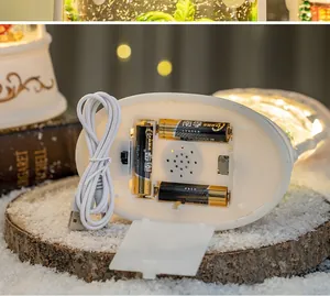 Detailed base showing dual USB and battery power options for the Christmas music snow globe