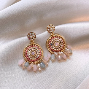 Detail of vintage silver needle tassel earrings with pink beads on beige silk