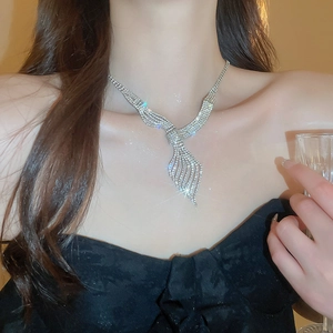 Detail of silver leaf rhinestone fringe necklace on model for luxury gala style
