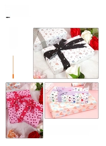 Detail of heart pattern gift wrap with gold foil and decorative polka dot ribbons