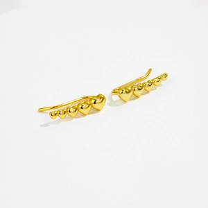 Close-up of elegant gold heart-shaped ear crawlers with zircon stones on white background