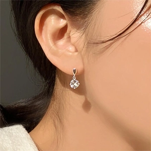 Detail view of 925 sterling silver flower earrings with zircon on model's ear